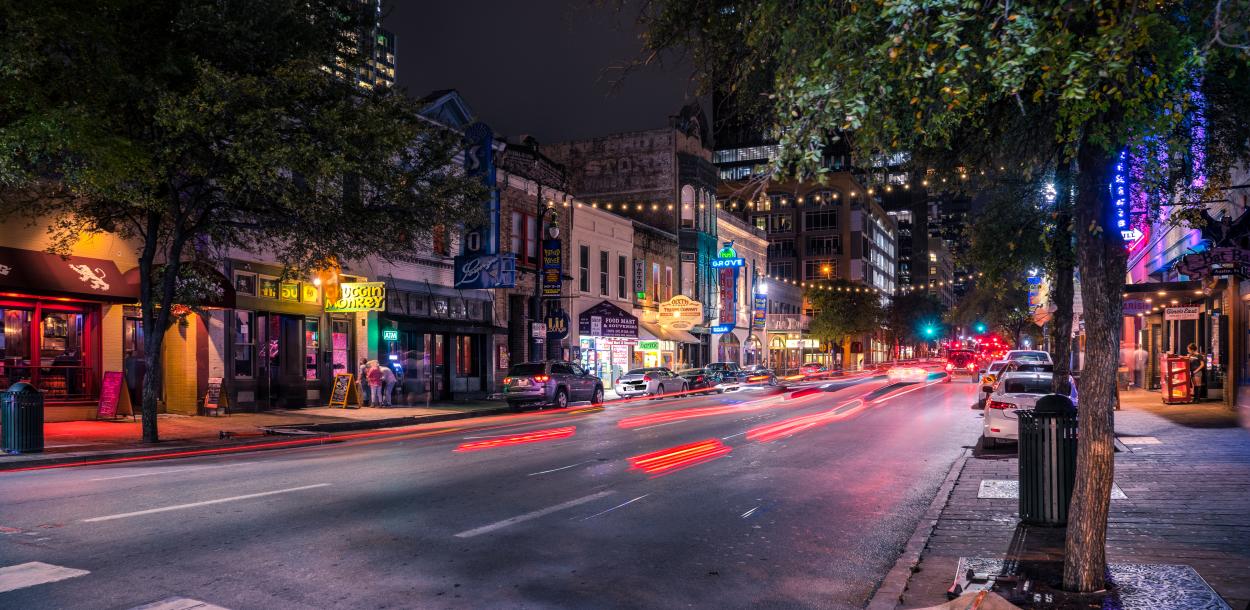 Timelapse street-view of Sixth Street at night with Frost tower n the background
